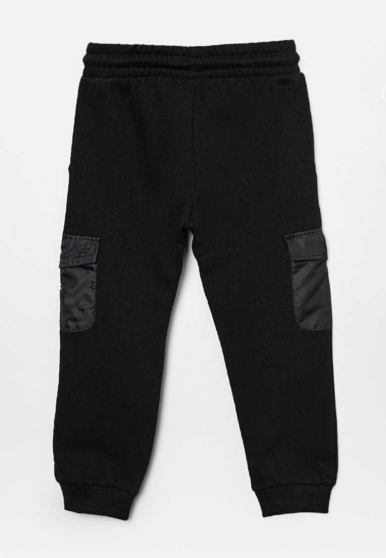 Pantalon de survêtement noir avec taille élastique, deux poches latérales et accents en nylon noir contrastant sur les poches. Tissu doux avec des poignets ribbés.
