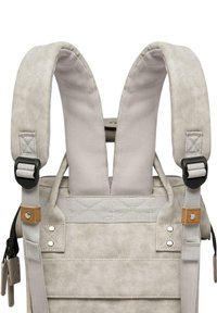 Grau gefärbter Rucksack aus weichem, strukturiertem Material, mit gepolsterten Trägern, verstellbaren Beschlägen und kontrastierenden, tanfarbenen Akzenten. Kompaktes Design mit Reißverschlussverschluss.