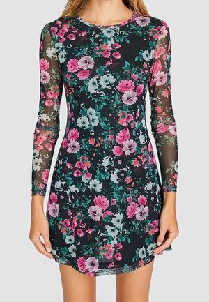 Strak zittende zwarte jurk met lange mouwen, voorzien van een bloemenpatroon in roze, paars en groen en doorschijnende mouwen.