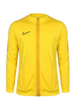 Geel sportjack met lange mouwen, ritssluiting aan de voorkant en zwart logo op de borst. Soepele stof, slim fit ontwerp, twee zijzakken.