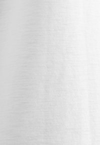 Texture de tissu blanc uni avec un motif de tissage fin et uniforme et un éclairage doux.