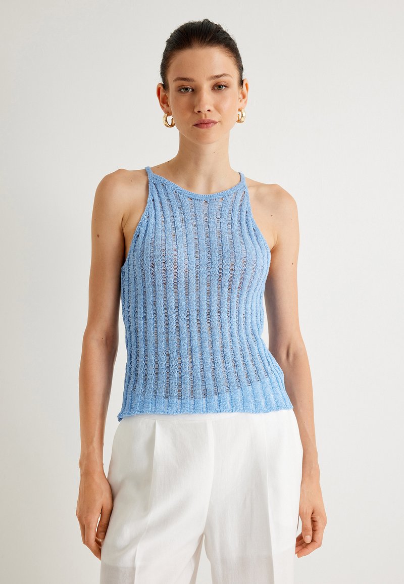 Vaaleansininen ribatulla neuleella varustettu tanktoppi, jossa on ohuet hihnat ja pyöreä pääntie, läpikuultavalla materiaalilla, yhdistetty valkoisiin leveälahkeisiin housuihin.