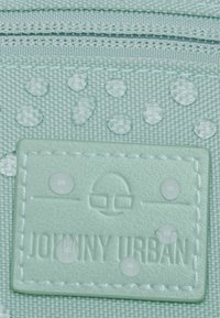 Světlomodrá voděodolná tkanina s vystouplými kapkami, s texturovanou nášivkou s reliéfním nápisem "JOHNNY URBAN" a jednoduchými grafickými detaily.