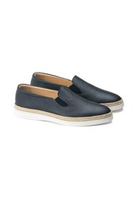 Chaussures noires en cuir à enfiler avec panneaux élastiques sur les côtés, semelle intermédiaire en jute et semelle en caoutchouc blanche. Texture lisse avec des détails de couture minimaux.