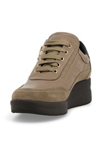 Sneaker beige con una combinazione di pelle e camoscio, caratterizzata da occhielli dorati, lacci testurizzati e un accentuazione nera sul tallone. Design della suola con zeppa.