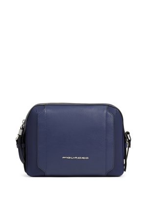 Bolso bandolera compacto de piel azul marino con logo plateado de Piquadro y correa ajustable sobre fondo blanco.