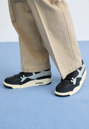 Czarno-szare sneakersy z teksturowanej skóry i materiału siateczkowego, z grubą, off-white podeszwą, z wiązaniem i wyraźnymi akcentami w kształcie szpicu.