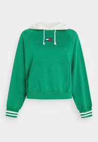 Sudadera verde corta de algodón, con capucha blanca con cordones, bolsillo frontal y puños a rayas blancas y verdes. Parche del logo en el pecho.