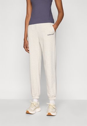 Pantalon de jogging gris clair avec poignets élastiques, poches latérales et logo « BJÖRN BORG ». Associé à un haut sans manches bleu marine et des baskets neutres.