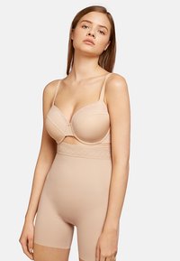 Conjunto de lencería beige que incluye un sujetador con relleno y detalles de encaje, y una braguita moldeadora de talle alto. Textura suave con un acabado liso.