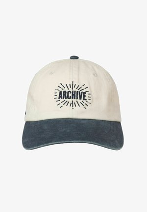 Casquette en coton crème avec visière bleu marine. "ARCHIVE" brodé en bleu marine avec des lignes rayonnantes. Bride arrière réglable pour l'ajustement.