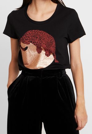 Black cotton T-shirt featuring a sleeping leopard graphic in red and glittery gold, with a round design on the front.