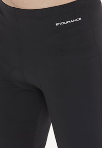 Schwarze Sportshorts aus elastischem Material, mit enganliegenden Schnitt, Nähdetails und "ENDURANCE"-Logo am Bund.