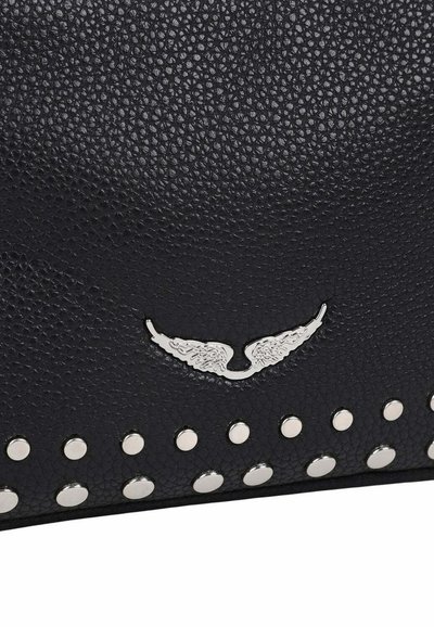 Surface en cuir texturé noir avec un emblème argenté en forme d'aile au-dessus de deux rangées de clous ronds argentés.