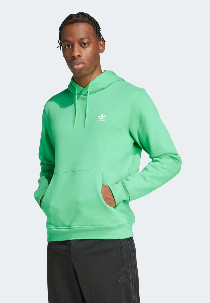 Groene katoenen hoodie met een voorzak en een trekkoord capuchon, voorzien van een klein wit Adidas-logo op de borst. Draag met zwarte broek.