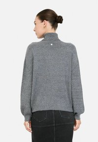Grau gestrickter Pullover mit hohem Kragen, lockerer Passform und geripptem Saum. Besitzt eine dezente glitzernde Textur und eine Knopfdetaillierung am Rücken.