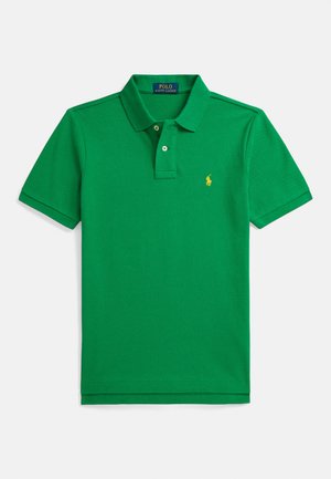 Camisola polo de algodão verde com gola, pala com três botões e um pequeno logótipo amarelo bordado no lado esquerdo do peito. Mangas curtas.