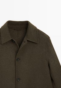 Brun uldblandingsfrakke med krave, frontknapper og en struktureret overflade. Designet er struktureret med rene linjer.