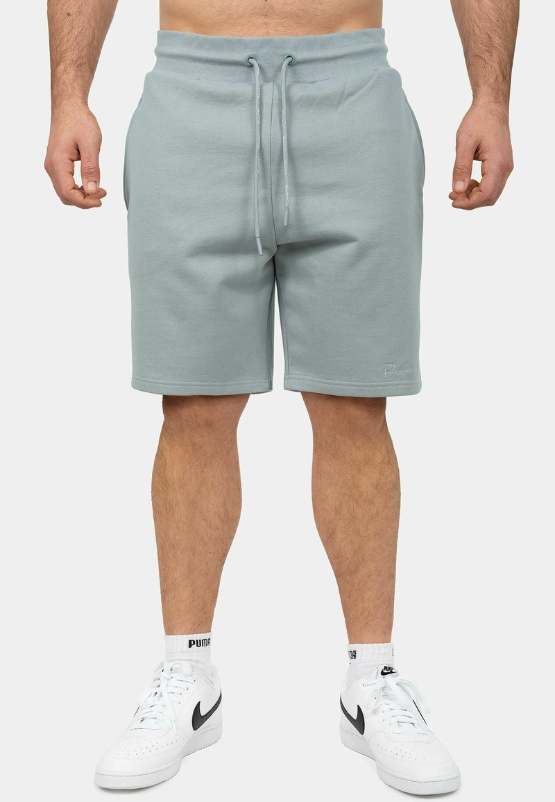 Lichtblauwe sportshorts van zacht materiaal, met een elastische tailleband met trekkoord, zijzakken en een ontspannen pasvorm.