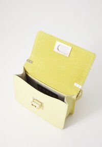 Borsa in pelle gialla con interno in suede. Presenta una chiusura magnetica, hardware in tono oro e una foderatura con motivo.