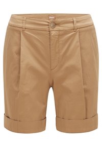 Beige skräddarsydda shorts med uppvikta fållar, framfållar, bältesöglor, knappstängning och en liten synlig varumärkesetikett i mitten av midjan.