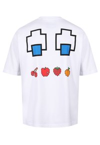 Camiseta blanca de algodón con un diseño en la parte posterior que presenta formas pixeladas azules y frutas en arte pixel: cerezas, manzana, fresa y naranja.