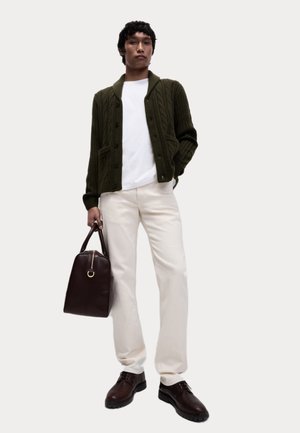 Grön stickad cardigan med fickor, vit t-shirt, krämfärgade byxor, bruna läderskor och en mörkbrun handväska med gulddetalj.