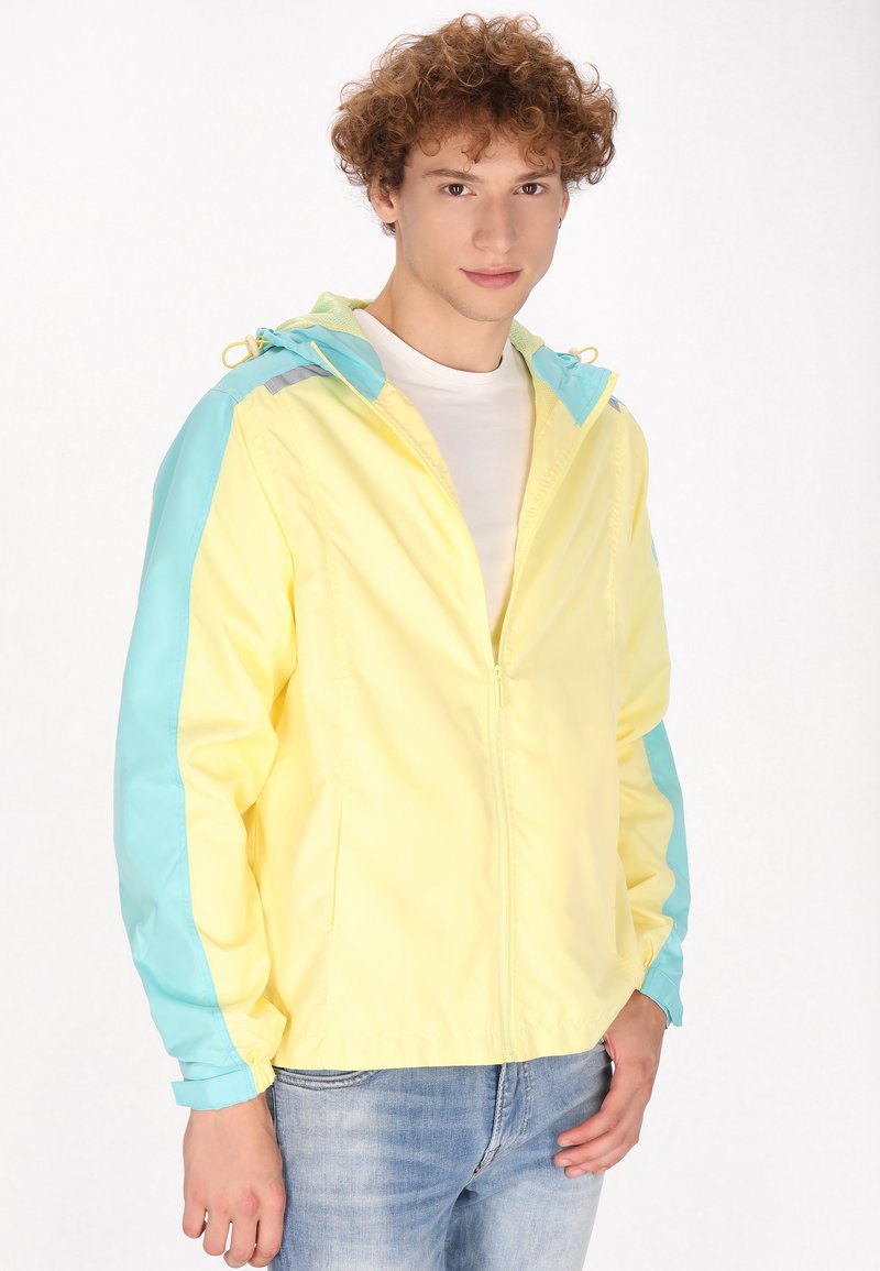 Leichte, mit Reißverschluss versehenen Jacke in Gelb und Aqua, ausgestattet mit einer Kapuze, elastischen Bündchen und einer glatten Textur mit kontrastierenden Farbblockierungen.
