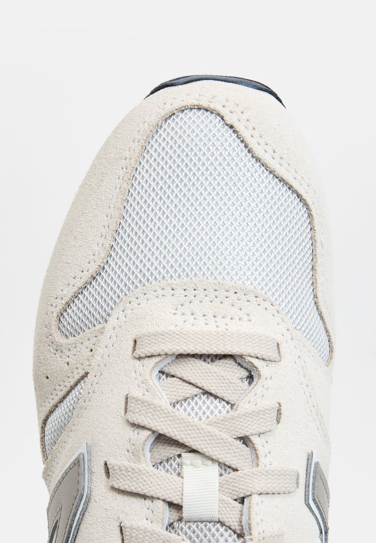 Baskets gris clair en combinaison de daim et de mesh. Les accents notables incluent des lacets tonal et un design élégant.