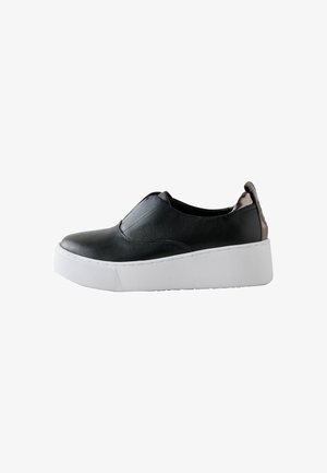 Baskets noires slip-on avec tige en cuir texturé, semelle plateforme blanche épaisse et languette métallique au talon, vues de côté sur fond blanc.