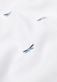 Tejido blanco con un patrón repetido de pequeñas libélulas en azul y negro, con una textura suave y un brillo sutil.