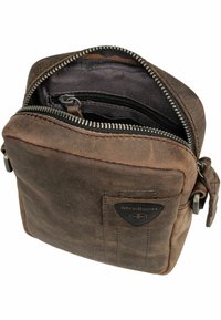 Borsa a tracolla in pelle marrone con chiusura a zip. Presenta una superficie testurizzata, scomparti interni e un'etichetta con logo sul davanti.