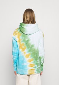 Sudadera con capucha en un patrón de tie-dye de azul, verde y amarillo. Presenta mangas largas y un ajuste relajado. Textura de tela suave.