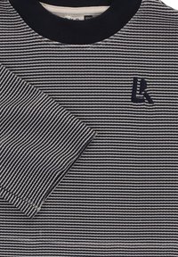 Gestreept shirt in marineblauw en wit, met een geribde zwarte kraag en een klein geborduurd logo. Katoenen materiaal met een gladde textuur.