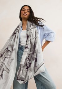 Grey and white patterned scarf made from lightweight fabric, featuring a marbled design and subtle shimmering accents.