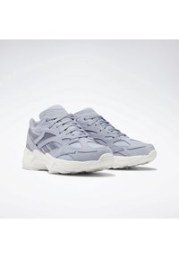 Ljust grå träningsskor med nät- och mockadetaljer, med en vit gummisula och accenter. Snörningsdesign, logotyp på tungan.