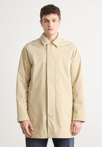 Μπεζ αδιάβροχο με κολάρο, κουμπωτό μπροστινό μέρος και μακριά μανίκια. Διαθέτει ραφές ράγλάν και απαλό υφή.