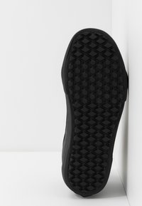 Černá gumová podešev boty s texturovaným, hexagonálním gripovým vzorem, se zakřiveným okrajem a hladkým bočním povrchem.