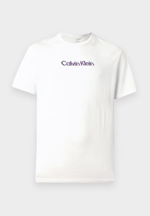 T-shirt en coton blanc avec col rond, manches courtes et logo "Calvin Klein" violet imprimé sur la poitrine.