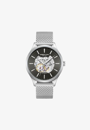 Silver automatisk klocka med nätarmband, svart urtavla, transparent baksida och silverfärgade timmarkörer. Har intrikata interna mekanismer.