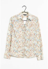 Camisa de botones con estampado floral sobre un fondo beige con patrones florales en azul y rojo. Mangas largas, cuello y dobladillo redondeado.