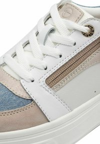 Sneaker bianco in denim, suede beige e dettagli metallici leggeri. Caratterizzato da lacci e cuciture bianchi, con un pannello laterale testurizzato.