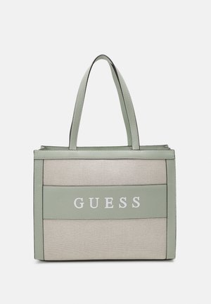 Sac fourre-tout rectangulaire beige et vert clair avec double poignée et le mot "GUESS" imprimé au centre avant.