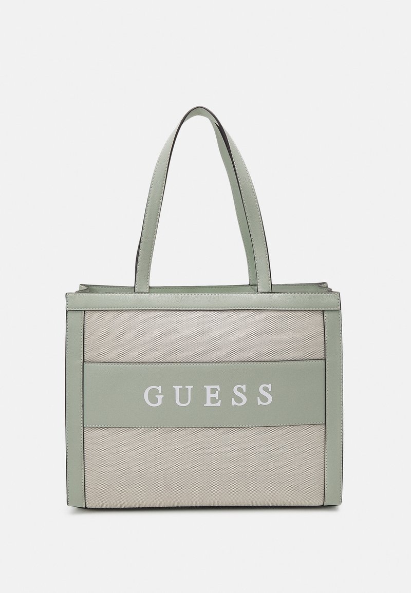 Sac fourre-tout rectangulaire beige et vert clair avec double poignée et le mot "GUESS" imprimé au centre avant.