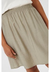 Jupe légère, de longueur genou, en tissu olive vert doux et texturé avec une taille élastique, présentant des plis légers pour un ajustement décontracté.