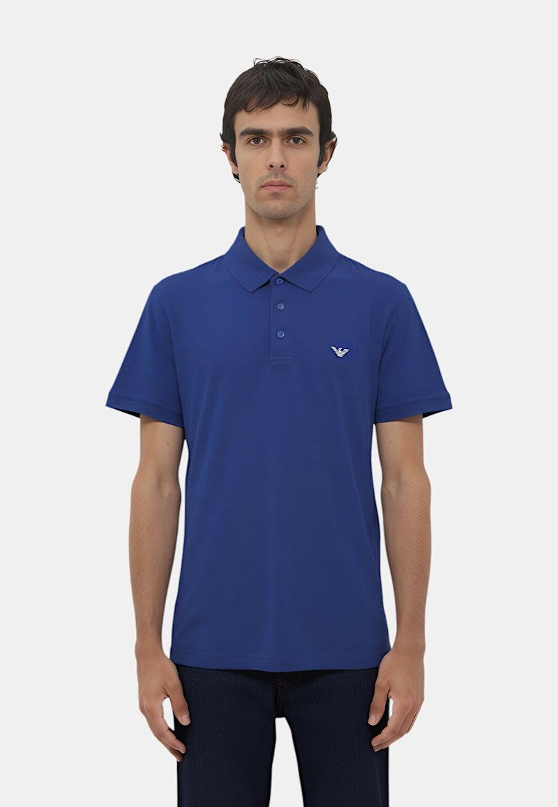 Polo shirt blu scuro realizzato in tessuto liscio, con colletto classico, maniche corte e un piccolo logo sul petto a sinistra.