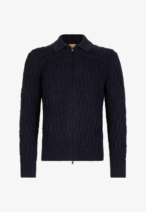 Marineblå strikket cardigan med fuld lynlås, der har et tekstureret mønster af sammenflettede former samt ribkant ved kraven og ærmerne.