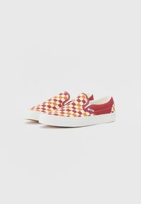 Red and orange checkered slip-on shoes with a white rubber sole and stitching accents. Textile upper with smooth, flat design.