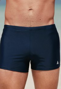 Marineblaue Schwimmshorts aus einem glatten, dehnbaren Stoff. Mit einem figurbetonten Design, einem elastischen Bund und einem kleinen Logo an der Seite.
