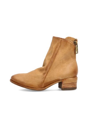 Tan læder ankelsko med lav stablet træsål og lynlåslukning i siden på hvid baggrund.